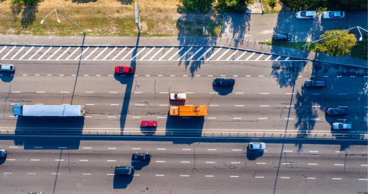 View form above on a busy highway with multiple cars of different make, color and type.