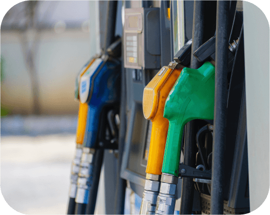 Green, orange and blue fuel nozzles at a petrol station.