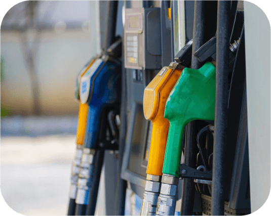 Groene, oranje en blauwe brandstofsproeiers bij een benzinestation.