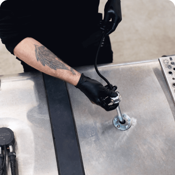 A Mapon technician installs a fuel sensor into the truck's tank.