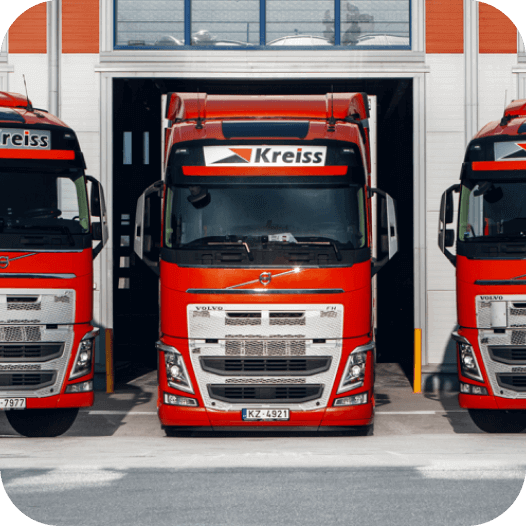 A photo of red trucks belonging to the Kreiss company that uses cold chain monitoring by Mapon.