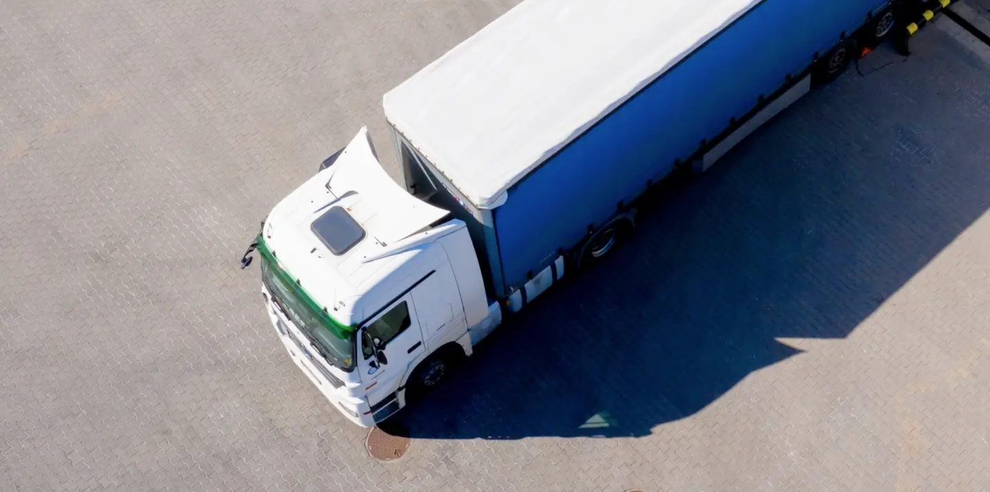 A white truck hauling a trailer as seen from above.