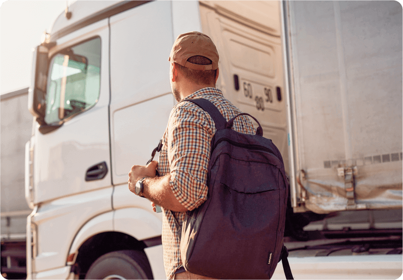 A photo of a person walking next to a large white truck that is equipped with fleet dash cams.
