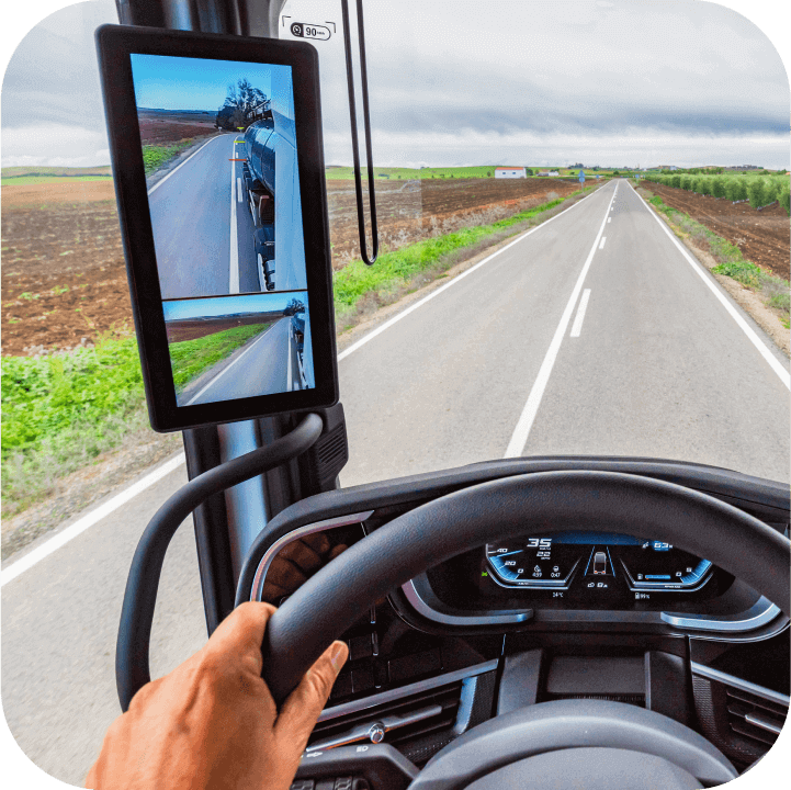 A view of the truck cabin, showing the monitor connected to a fleet camera system, providing the driver with a side view of the road.