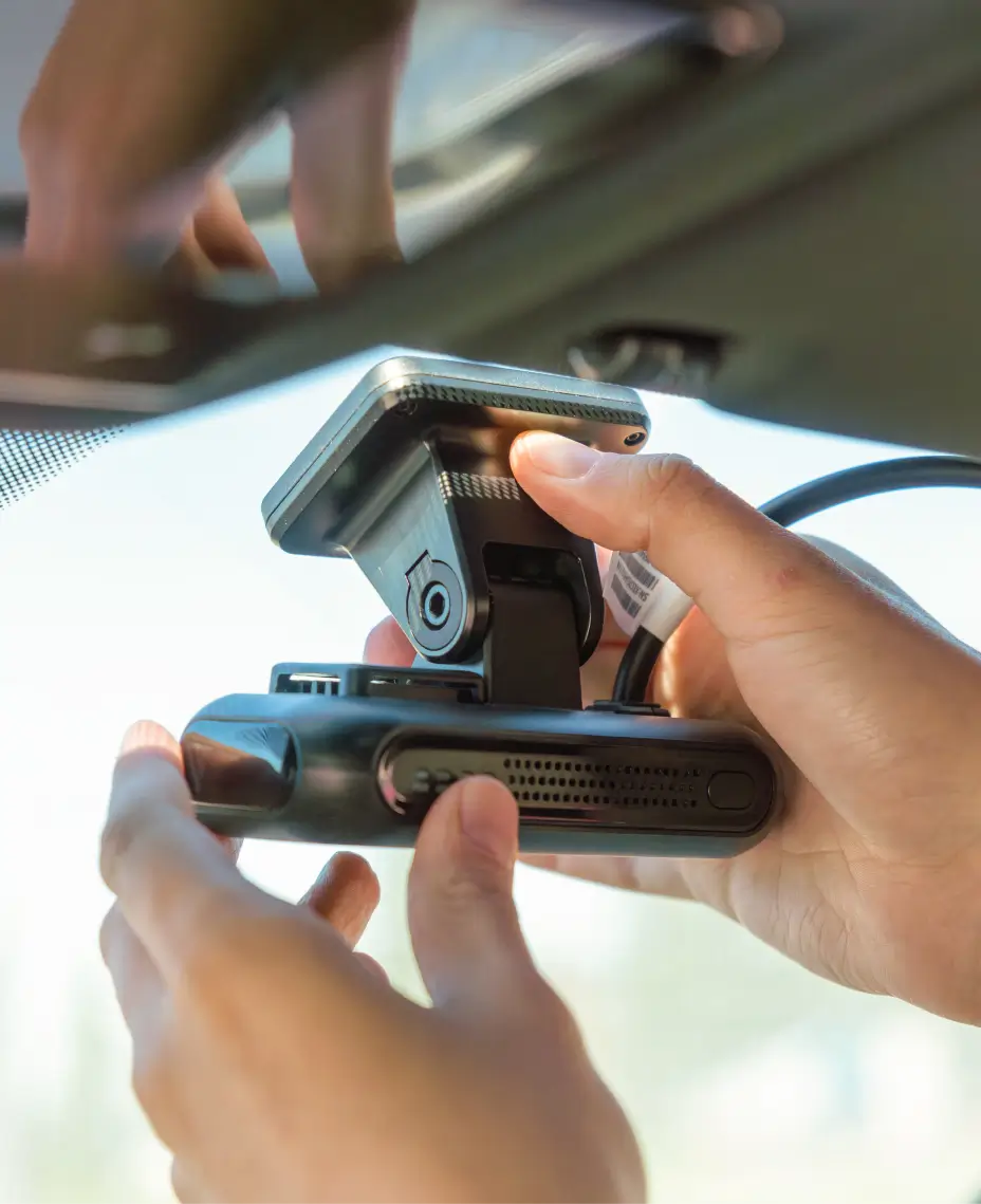 En person installerar en dashcam i en sopbil – viktig utrustning för fordonsövervakning inom avfallshantering.