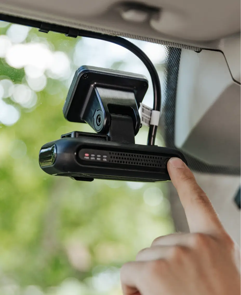 Tuvplāns, kur redzams cilvēks nospiež pogu uz transportlīdzeklī uzstādītas kameras.