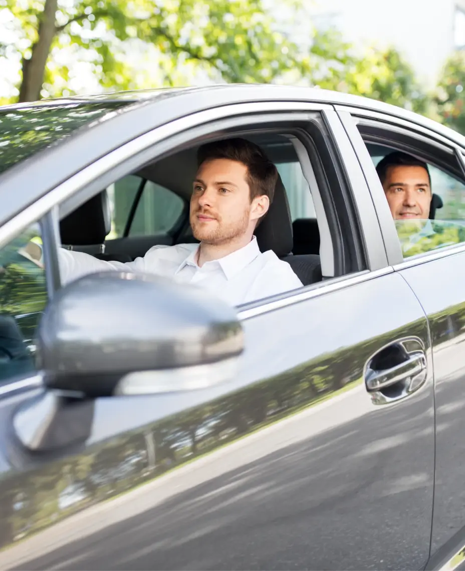 takin kuljettaja autossa, jossa matkustaja istuu takana