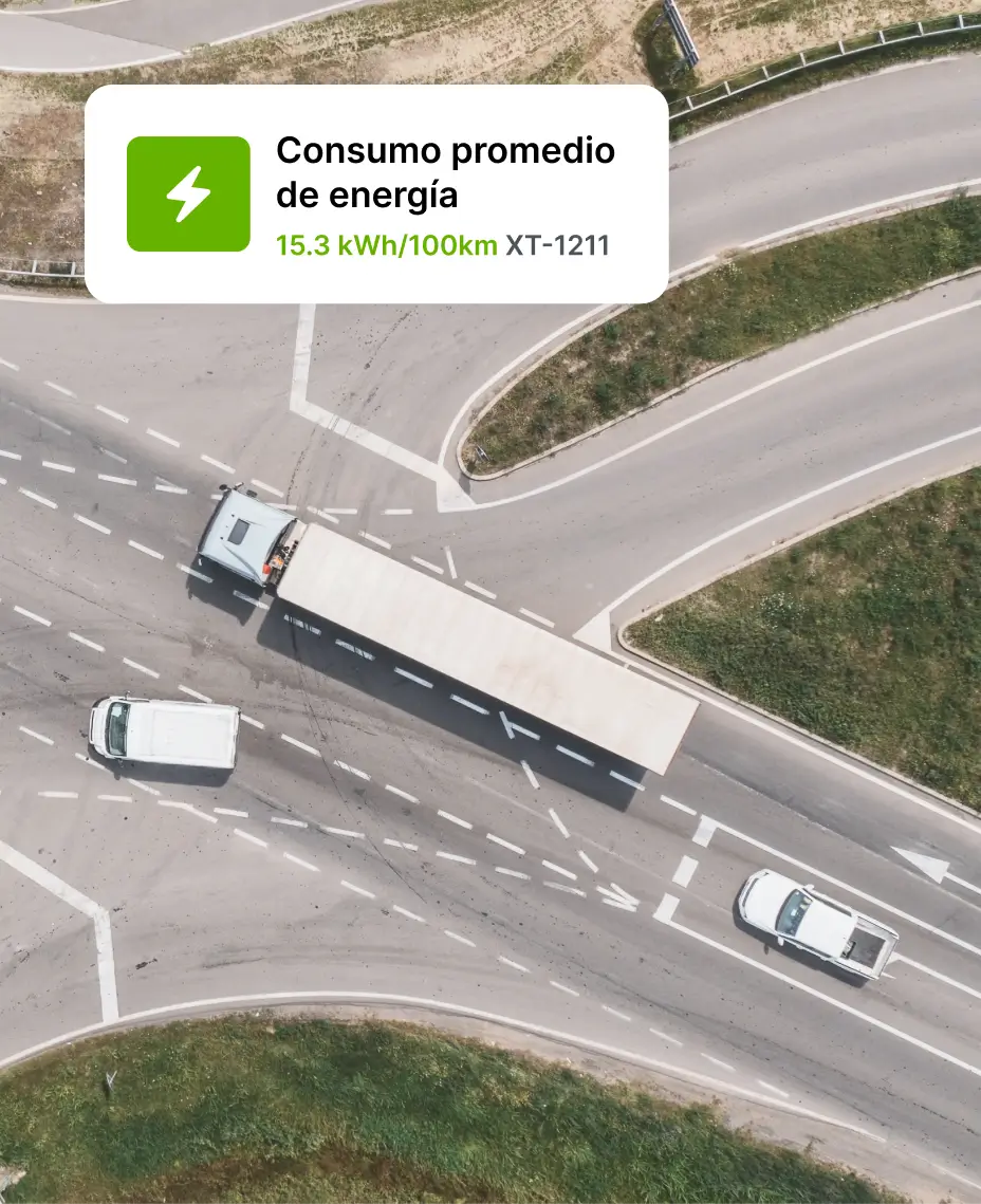 Vista aérea de camiones conduciendo en una intersección de carreteras con una superposición que muestra datos de consumo energético promedio.
