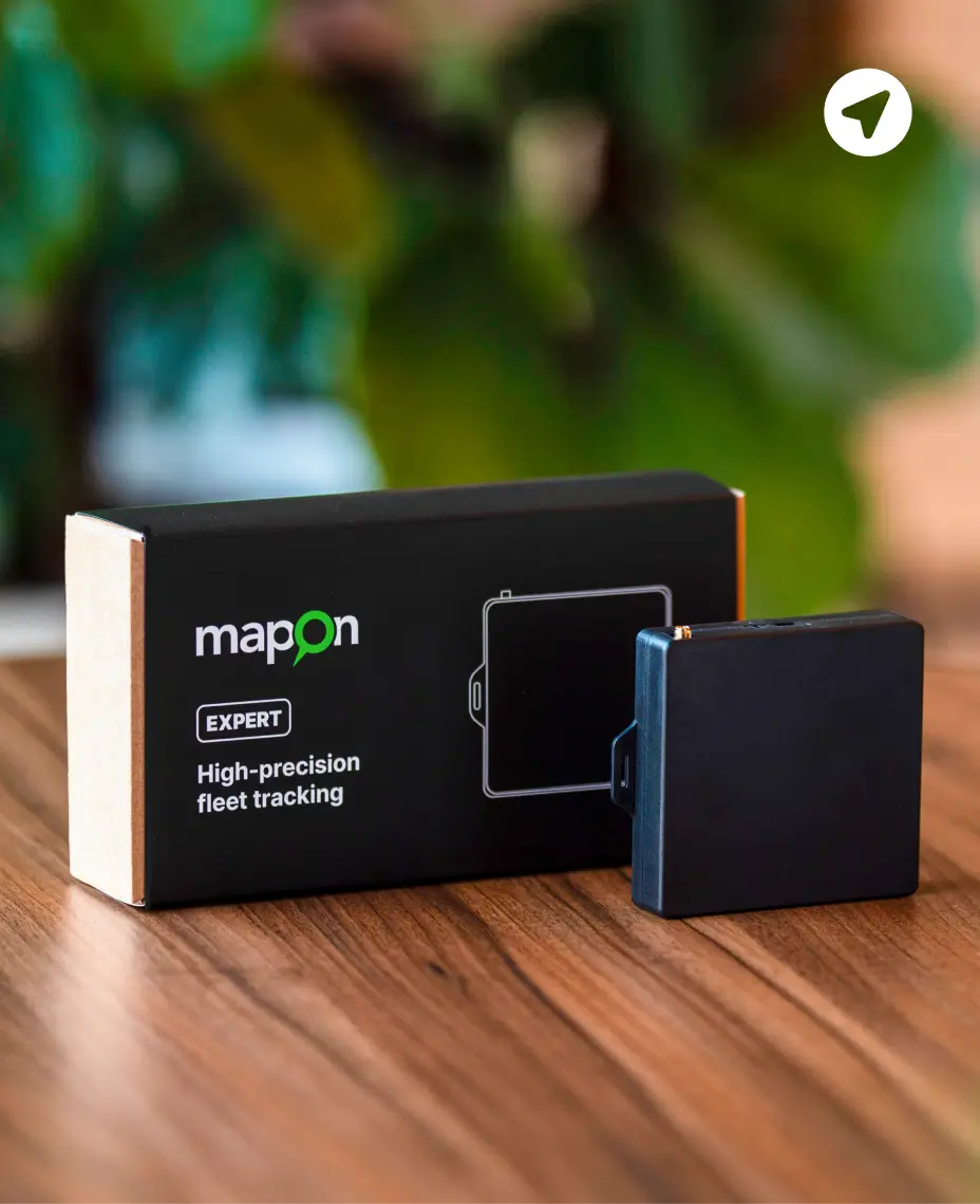 Dispositivo de seguimiento GPS Mapon Expert colocado sobre una mesa junto a su caja de embalaje.