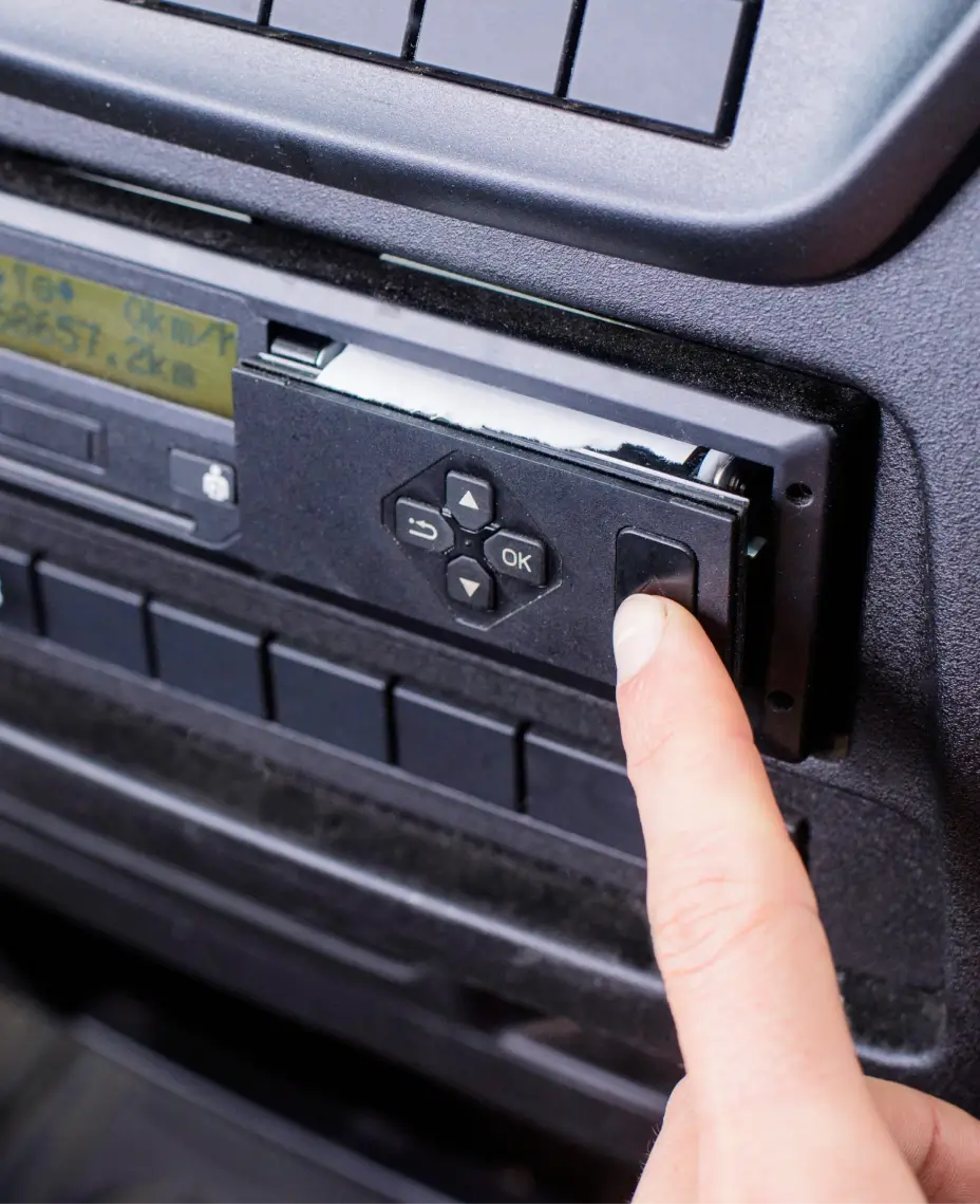 Primer plano de un conductor descargando datos del tacógrafo de forma remota desde una unidad de tacógrafo digital.