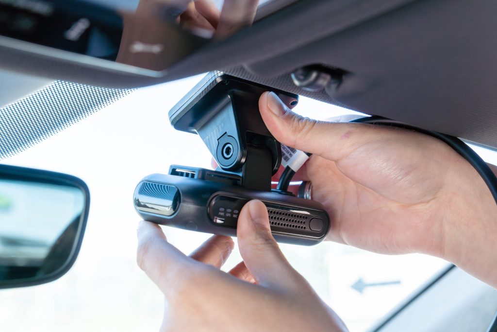 A fleet camera is being installed inside a vehicle cabin.
