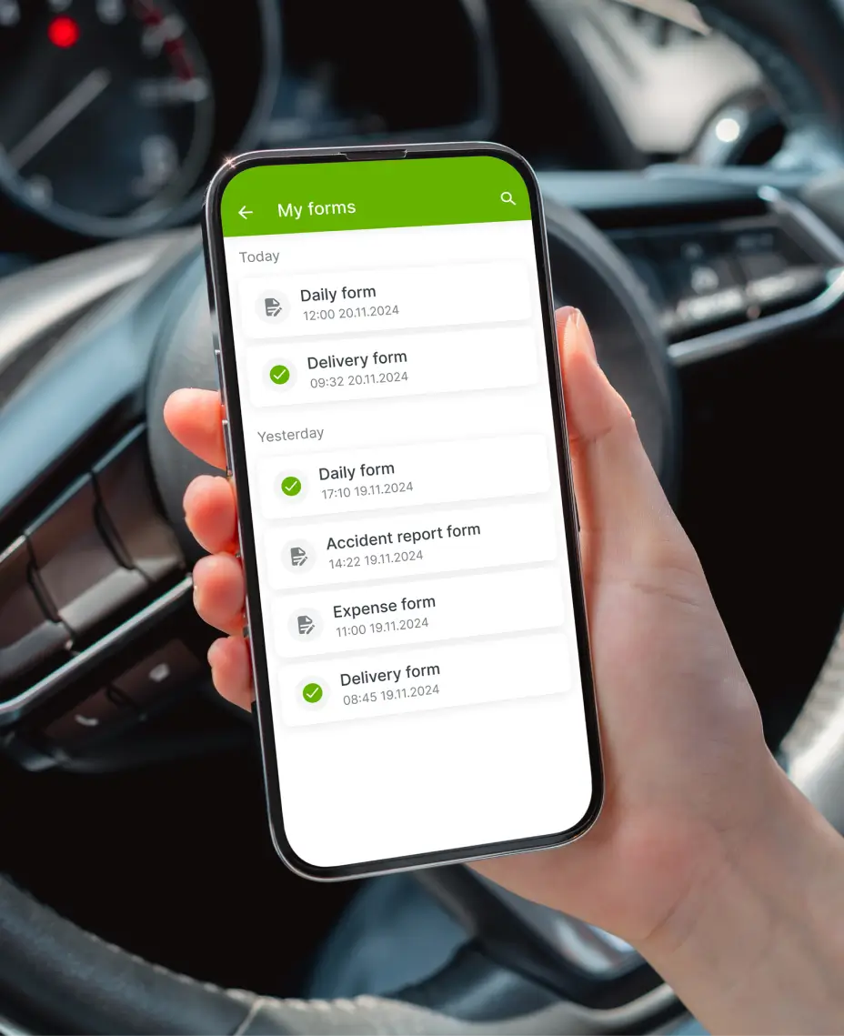 Persona sosteniendo un teléfono inteligente dentro de un coche, mostrando la aplicación Mapon Driver con formularios de informe diario, de entrega y de accidentes.