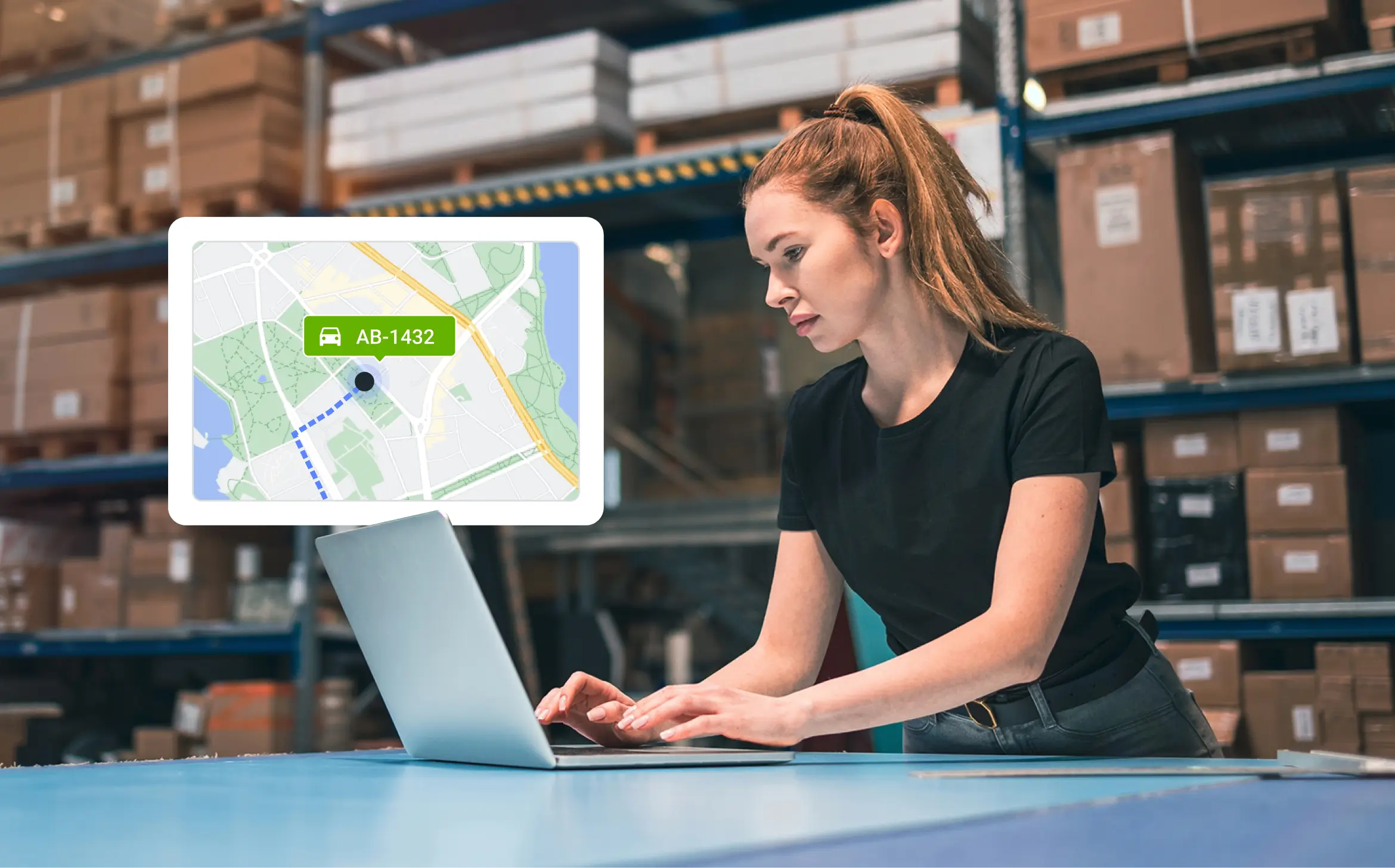 Kvinna i ett lager som använder en laptop för att dela fordonets liveposition på Mapon-plattformen.