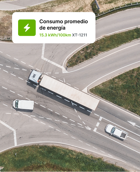 Vista aérea de camiones conduciendo en una intersección de carreteras con una superposición que muestra los datos de consumo energético promedio.