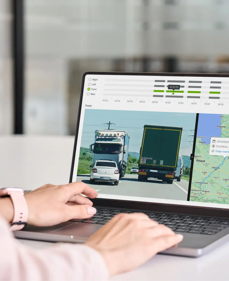 Fleet manager reviewing AI dashcam footage and telematics data on laptop for fleet safety management.
